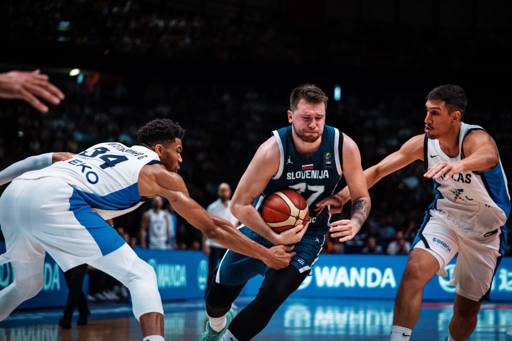 Luka Dončić trying to dribble past Giannis Antetokounmpo